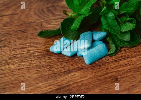 Le gomme da masticare e verde menta su uno sfondo di legno Foto Stock