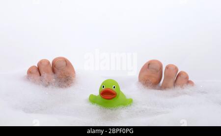 Uomini in piedi in un bianco luminoso con vasca, il fuoco selettivo sulle dita dei piedi Foto Stock