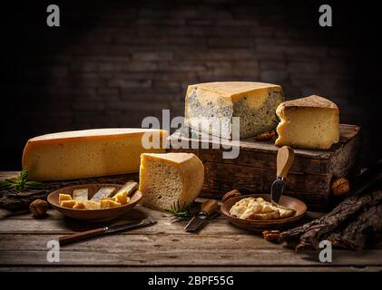 Formaggio a pasta dura di produzione domestica in assortimento su uno sfondo di legno Foto Stock