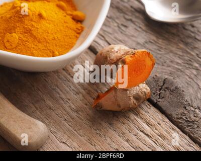 Curcuma rizoma e polvere su una tavola in legno rustico, vista da sopra Foto Stock