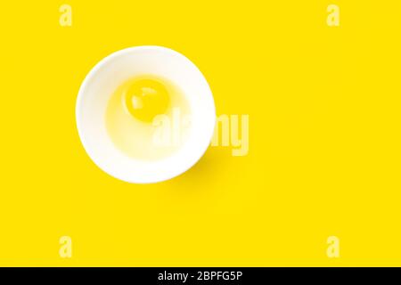Uova gregge in recipiente su sfondo giallo. Cibo sano e cucina a casa concetto. Foto Stock