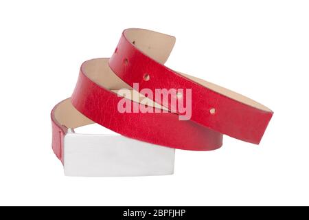 Cintura in pelle isolata. Elegante cintura femminile in pelle arrotolata rossa isolata su sfondo bianco. Accessori donna alla moda. Macro. Foto Stock