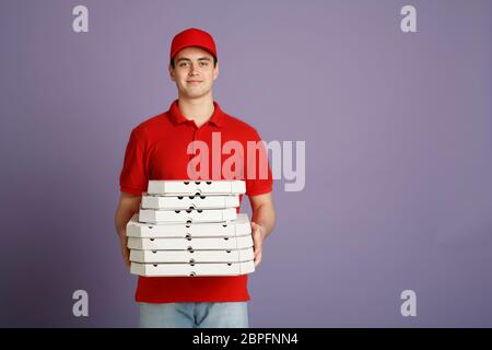 Festa e grande consegna di pizza a casa. Il corriere contiene molte scatole Foto Stock