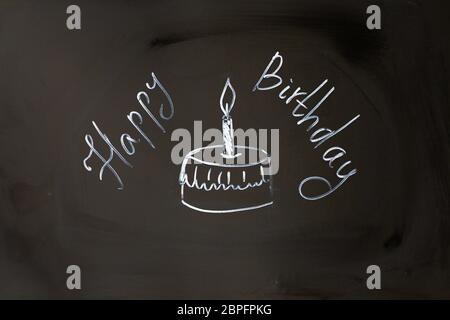 Chalk iscrizione buon compleanno tortina con candela. Foto Stock