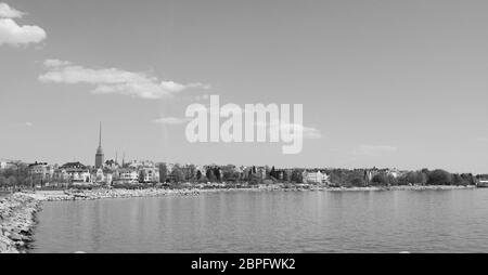 Vista dal litorale del quartiere di Munkkisaari, dall'altra parte dell'acqua fino al parco Birgitan Pyhän nel quartiere di Eira, Helsinki, Finlandia - lavorazione monocromatica Foto Stock