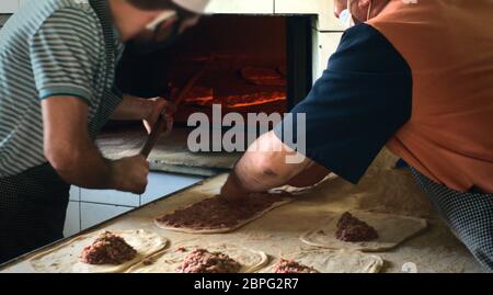 Due panettieri maschi musulmani che preparano e riscaldano la pita tradizionale turca nel mese più sacro del Ramadan Foto Stock