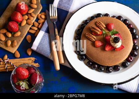 torte o pancake caldi con frutti rossi, fragole, more per colazione, vista dall'alto, orizzontale Foto Stock