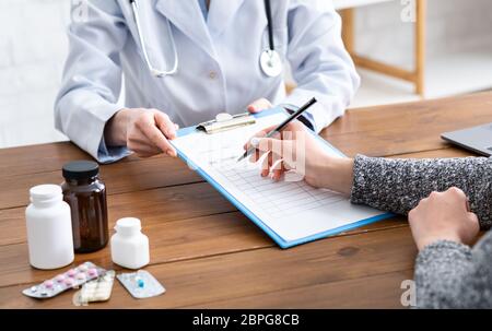 Il medico suggerisce di compilare il questionario per i pazienti, ritagliato Foto Stock