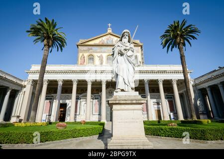 Bellissimo chiostro di San Paolo (Paolo) in Italia, Roma, statua chiesa e palme in background Foto Stock