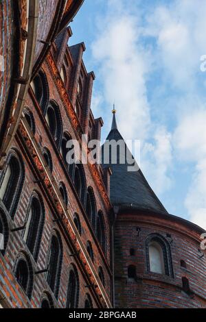Vista frontale di Holstentor a Lübeck verso il cielo, patrimonio dell'umanità dell'UNESCO, simbolo gotico storico paesaggio urbano ornamenti restaurati in mattoni Foto Stock