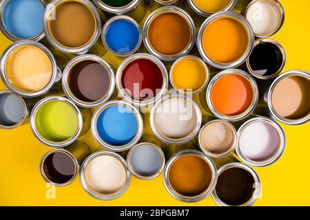 Le benne pieno di colore arcobaleno pittura ad olio su sfondo rosso Foto Stock