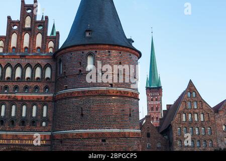 Vista frontale di Holstentor a Lübeck verso il cielo, patrimonio dell'umanità dell'UNESCO, simbolo gotico storico paesaggio urbano ornamenti restaurati in mattoni Foto Stock