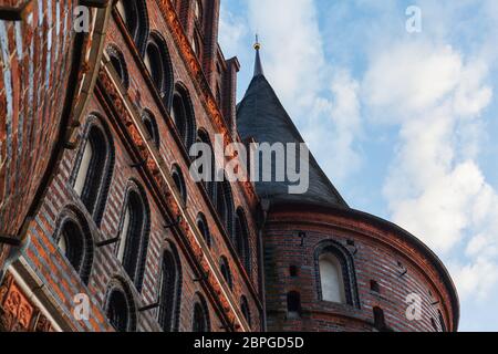 Vista frontale di Holstentor a Lübeck verso il cielo, patrimonio dell'umanità dell'UNESCO, simbolo gotico storico paesaggio urbano ornamenti restaurati in mattoni Foto Stock