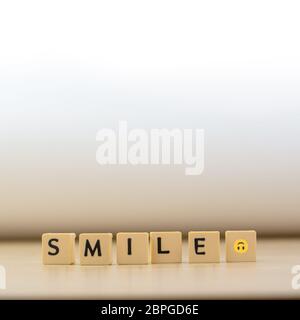 Parola sorriso scritta in cubo su pavimento di legno su sfondo bianco, blocchi di lettere si dispone in PAROLE SORRIDENTI, per aggiungere testo o altre immagini o design Foto Stock