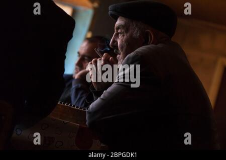 Gli uomini nel villaggio di Lahic si riuniscono nel negozio di tè per incontrare e giocare a dominos mentre beve tè e fumando sigarette in Azerbaigian Lahic. Foto Stock