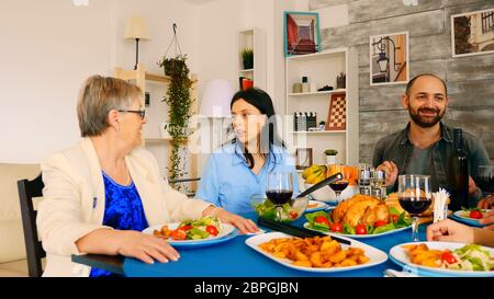 Ingrandisci lo scatto di una bella giovane donna che parla con sua madre negli anni sessanta a cena in famiglia. Foto Stock