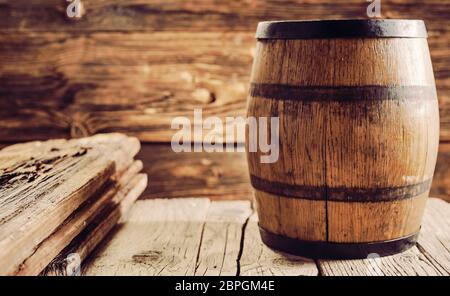 Botti di rovere per l'alcol invecchiamento, in piedi sul vecchio tavolo in legno in casa rustica. Spazio di copia Foto Stock