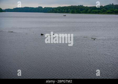 Fiume Daugava vicino Koknese. Vista del fiume Daugava, in barca con i pescatori in distanza. Paesaggio lettone. Paesaggio del fiume Daugava in Lettonia. Foto Stock