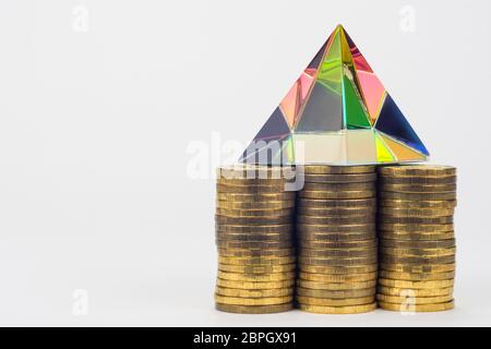 Tre pile di monete, vi è una piramide di vetro su di essi, a destra è uno spazio vuoto Foto Stock