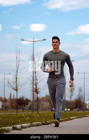 Il bel giovane sportivo è jogging in strada all'aperto. Foto Stock