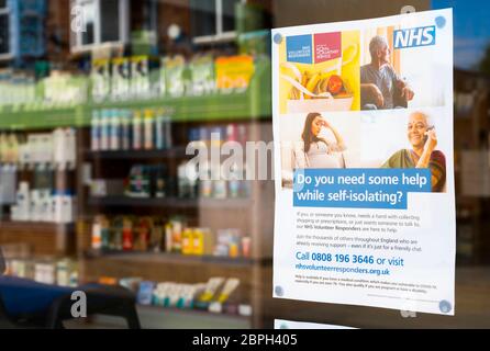 Poster in una vetrina di farmacia durante la pandemia di Covid-19, Market Harborough, Leicestershire, Inghilterra. Foto Stock