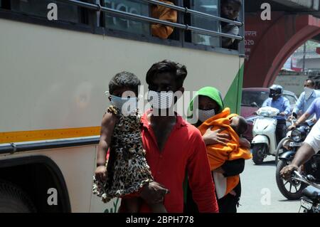 Nuova Delhi, India. 19 maggio 2020. Un lavoratore migrante con la sua famiglia si avvicina a un autobus per tornare al suo villaggio in Uttar Pradesh dalla periferia di Delhi. Un gran numero di lavoratori è disperato a tornare ai loro villaggi e città, perché sono stati lasciati senza lavoro a causa del blocco continuo per contenere il coronavirus. (Foto di Sondeep Shankar/Pacific Press) Credit: Pacific Press Agency/Alamy Live News Foto Stock