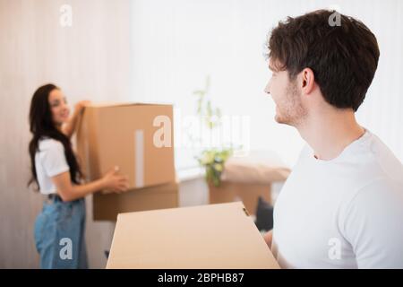 Giovane coppia che trasporta grande scatola di cartone a casa nuova home.moving Foto Stock