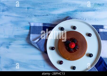 torte o pancake caldi con frutti rossi, fragole, more per colazione, vista dall'alto, orizzontale Foto Stock