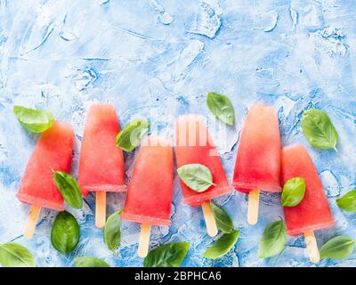 Vista dall'alto di cocomero e basilico popsicles con copia spazio. Ricetta Popsicles idea. Foto Stock