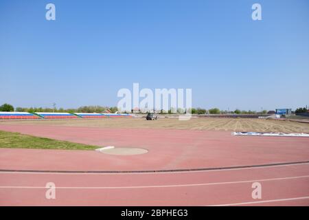 Slavyansk-on-Kuban, Russia - 25 aprile 2019: Lavori di riparazione allo stadio. Erogazione e livellamento della sabbia. Foto Stock