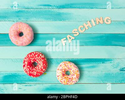 Il carnevale di turchese sfondo con ciambelle e decorazione Foto Stock