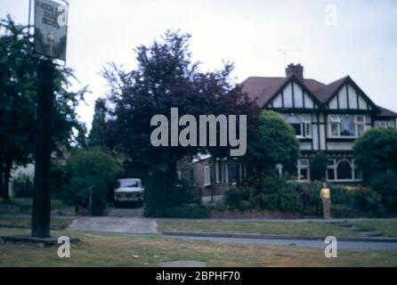 Una casa a conduzione familiare semi indipendente in stile Tudor mock costruita nel 1937, con alberi, arbusti e canne nel giardino anteriore e un'Alfa Romeo Giulia Super beige parcheggiata nel drive a Hatch End Park Estate, Milne Feild, Middlesex, UK Foto Stock