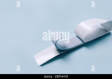 Blu Tack a forma di sottile striscia piatta su sfondo blu. Foto Stock