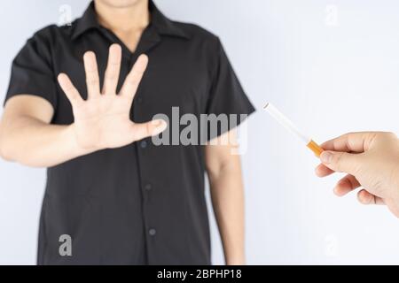 Giovane uomo sano che rifiuta di prendere la sigaretta di smettere di fumare concetto. Giornata del tabacco. Foto Stock