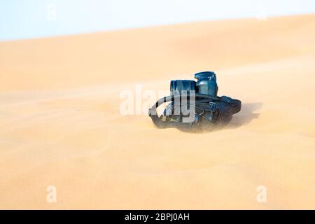 La fotocamera si trova su uno zaino nel deserto. Foto Stock