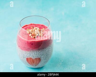 Idea per una sana prima colazione il giorno di San Valentino: Chia pudding con bacca rossa, purea di mandorle tritate sulla sommità e fragola a forma di cuore. Copia sp Foto Stock