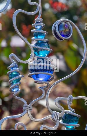 ornamento di palline di vetro blu e ferro battuto in un ambiente soleggiato all'aperto Foto Stock