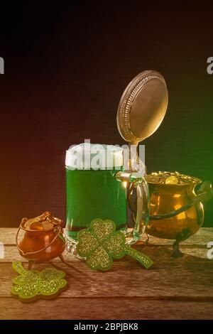 Pentola d'oro, birra e trifogli sul pannello di legno Foto Stock