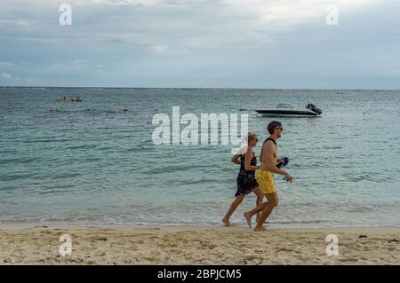 Mauritius, 2020 gennaio - Coppia che passeggiava in spiaggia e sorridente, godendo di vacanze estive su un'isola tropicale Foto Stock