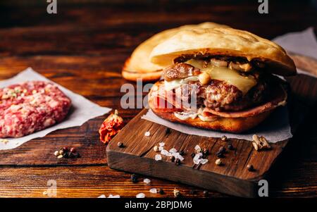 Cheeseburger con carne di manzo Patty, Wisconsin il formaggio svizzero, prosciutto, funghi saltati, Dijon senape, maionese e rotolo di patate. Foto Stock