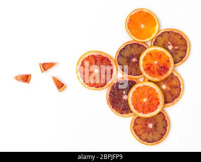Molti freschi fette di arance sanguigne si trovano magnificamente disposti su uno sfondo bianco Foto Stock