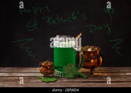 Felice per il giorno di San Patrizio chalk testo verde con birra, shamrock e monete Foto Stock