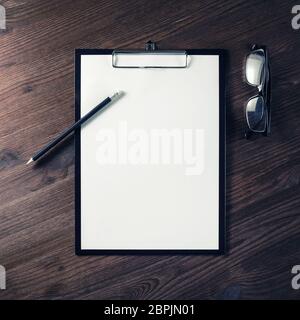 Foto di blank stationery impostato su sfondo di legno. Appunti, intestata, bicchieri e matita. Lay piatto. Foto Stock