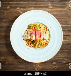 Lay piatto di pasta con il re di gamberetti grigi su sfondo di legno Foto Stock