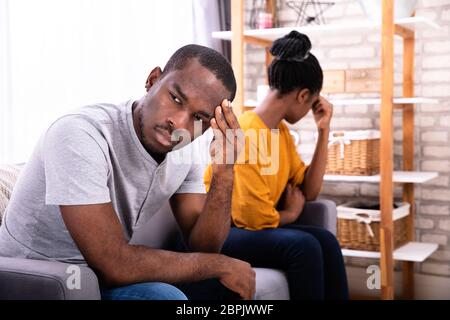 I giovani africani depresso giovane seduto sul divano Foto Stock