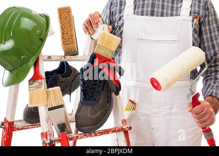 Gli strumenti di lavoro e le attrezzature di sicurezza professionali per il pittore della casa su un robusto scala di metallo. Casa pittore in background. Isolato su sfondo bianco Foto Stock