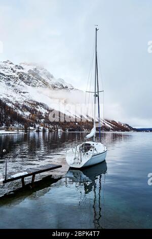 Barca a vela parcheggiata sul Lago di Sils. Cielo nuvoloso. Svizzera Foto Stock