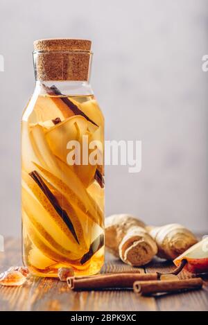 L'acqua aromatizzata con pera, radice di zenzero e cannella Stick. Alcuni ingredienti sul tavolo. Orientamento verticale e copia di spazio. Foto Stock