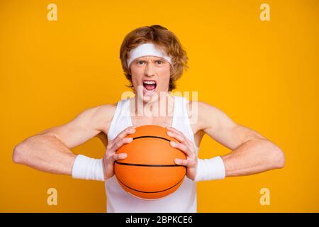 Primo piano ritratto del suo bel ragazzo sportivo emozionale preoccupato e attraente che tiene in mano la palla gettata isolata su brillante brillantezza Foto Stock