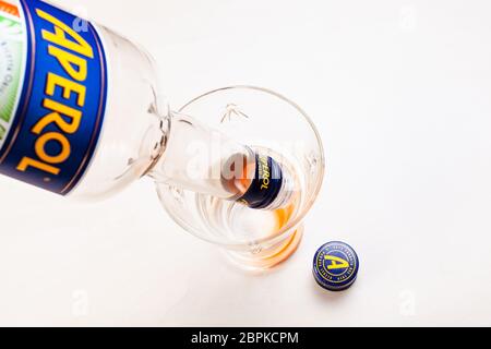 MOSCA, RUSSIA - 10 MAGGIO 2020: Assunzione di ultime gocce di bevande da bottiglia vuota di Aperol in vetro. Aperol è un classico aperitivo amaro italiano di Pa Foto Stock